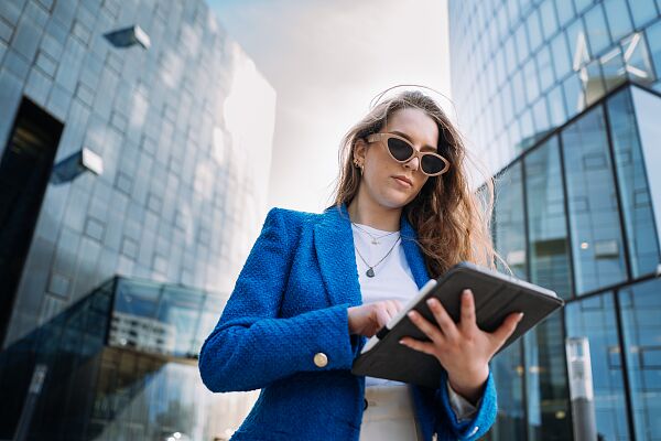 young-confident-woman-suit-using-tablet-dark-atmosphere-businesswoman-walking-office.jpg