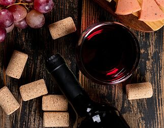 top-view-red-wine-with-grape-cheese-cutting-board-dark-wooden-vertical.JPG